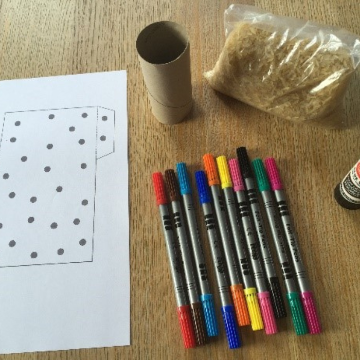Photograph of materials needed to make a paper shaker - paper, dried pasta, coloured pens and glue