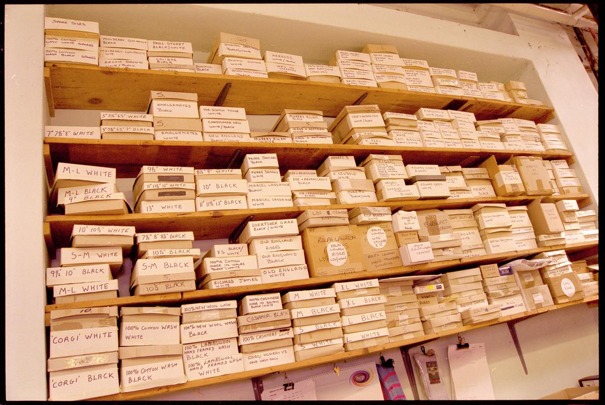 Wall shelves containing boxes of sock labels (size/designer/shop) at Corgi Hosiery Ltd factory, Ammanford, 1 July 2002.