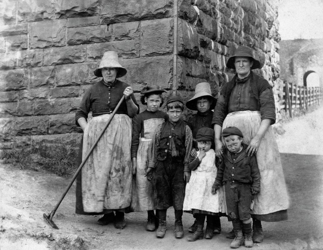 Group of two women and five children, former inhabitants of Rhyd-y-car, Merthyr Tydfil, Glamorgan.