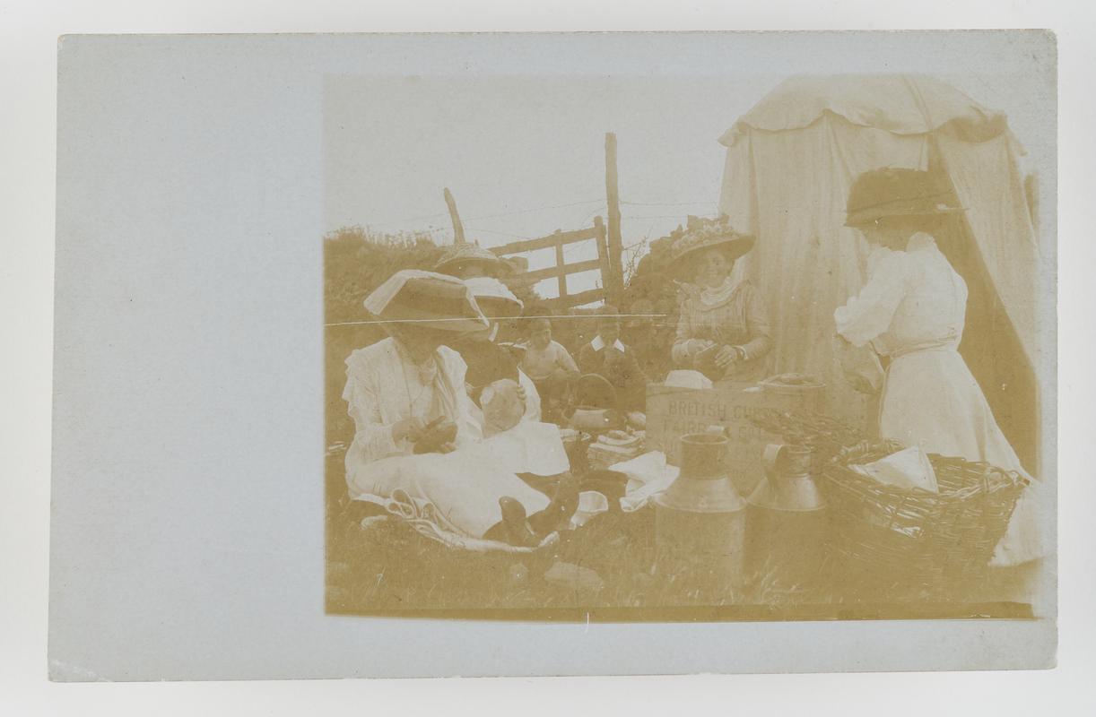 Group of  women and children having a picnic outside tent near New Quay, Cards.