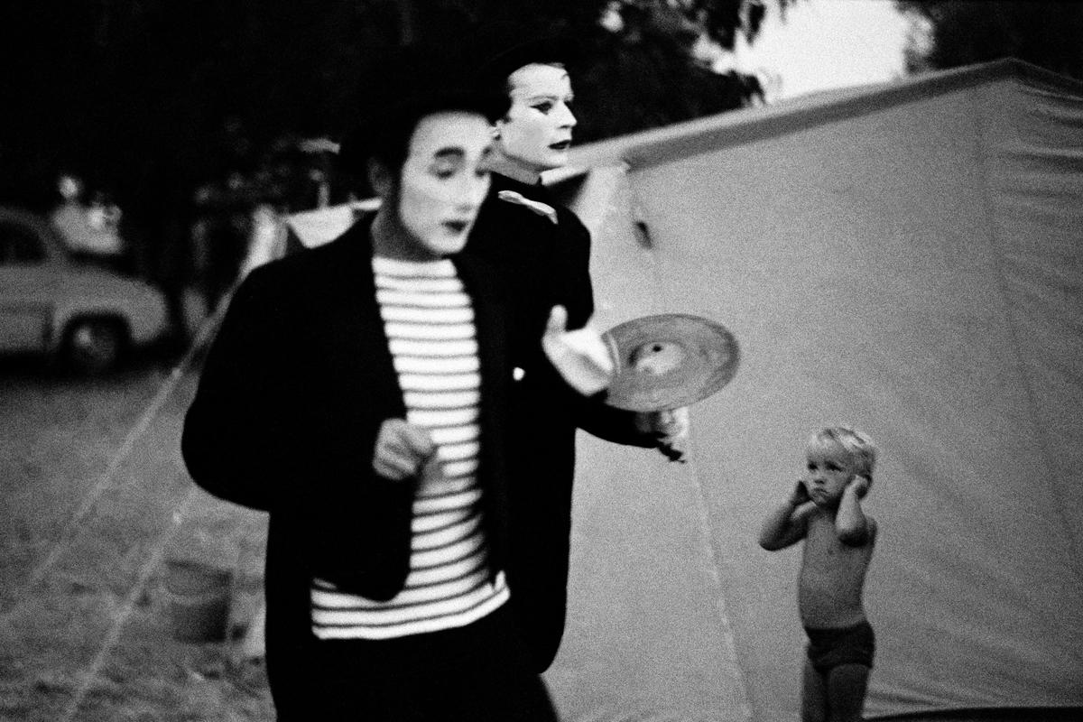 FRANCE. Saint-Tropez. Clowns from a travelling circus walk through the local camping site hoping to attract potential customers. 1964.