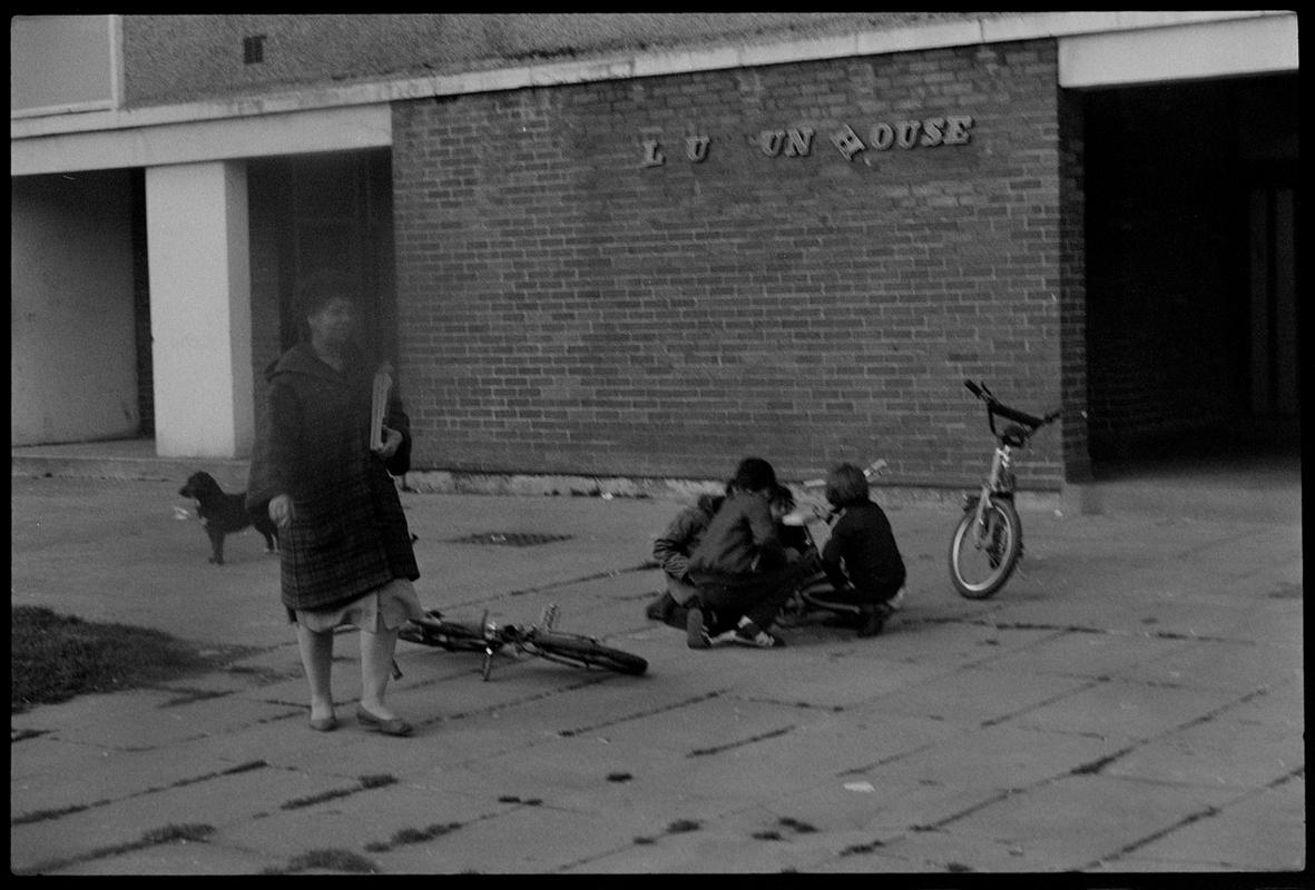 Children playing on bikes outside flats, Butetown.