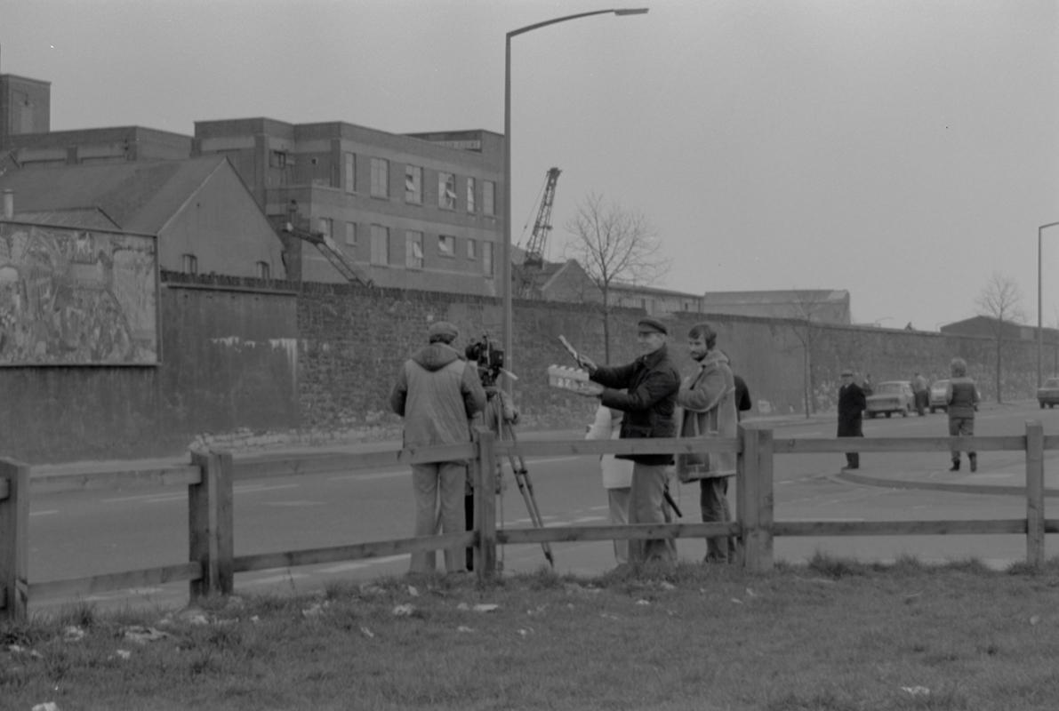 Film crew on Bute Street opposite mural on wall of railway embankment.