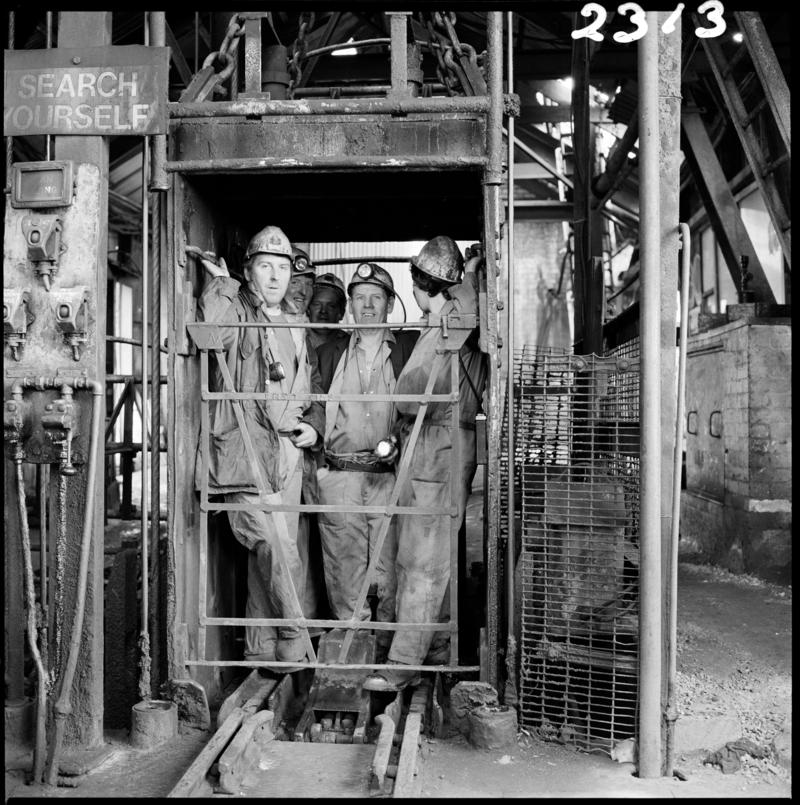 Black and white film negative showing miners in the cage at pit top, Morlais Colliery 13 May 1981.  &#039;Morlais 13/5/81&#039; is transcribed from original negative bag.
