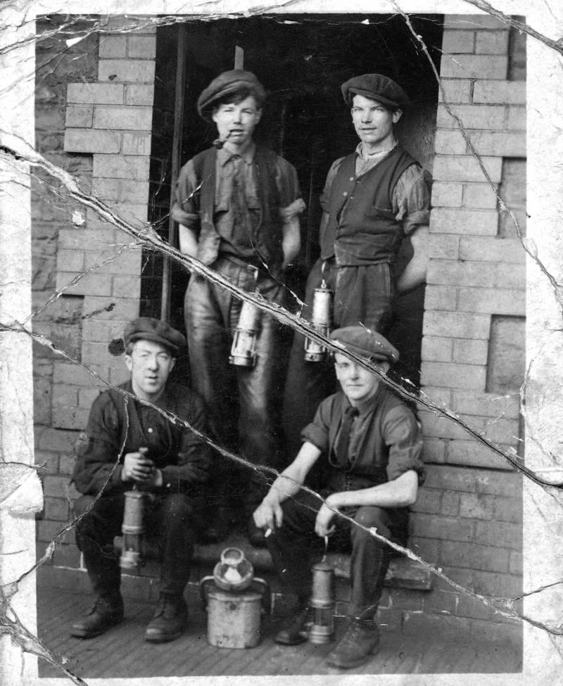 Four young miners in the doorway of Oakdale Colliery lamproom