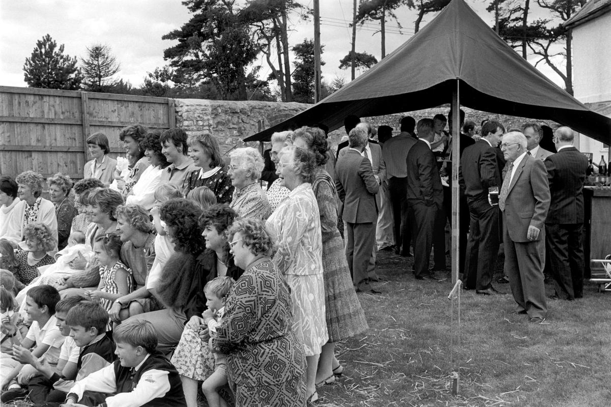 GB. WALES. Castleton. Family gathering for a photograph of the women and children. Men in the beer tent. 1989.