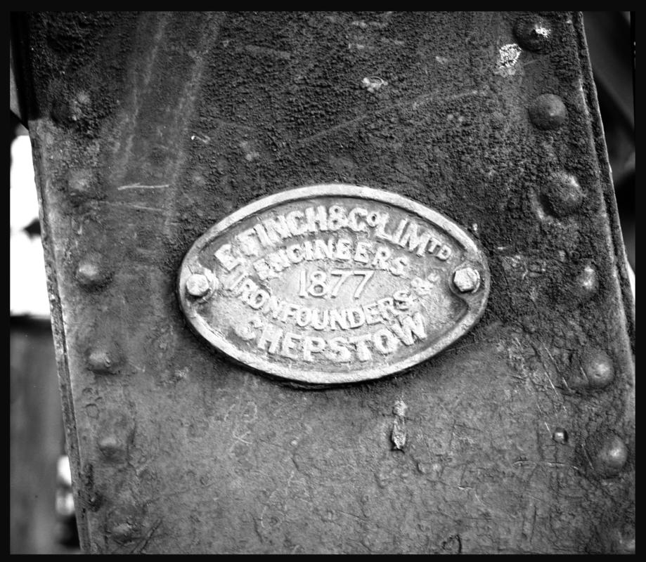 Black and white film negative showing a maker&#039;s plate on ironwork engraved with &#039;E. Finch &amp; Co Ltd Engineers, 1877, Ironfounders, Chepstow&#039;.