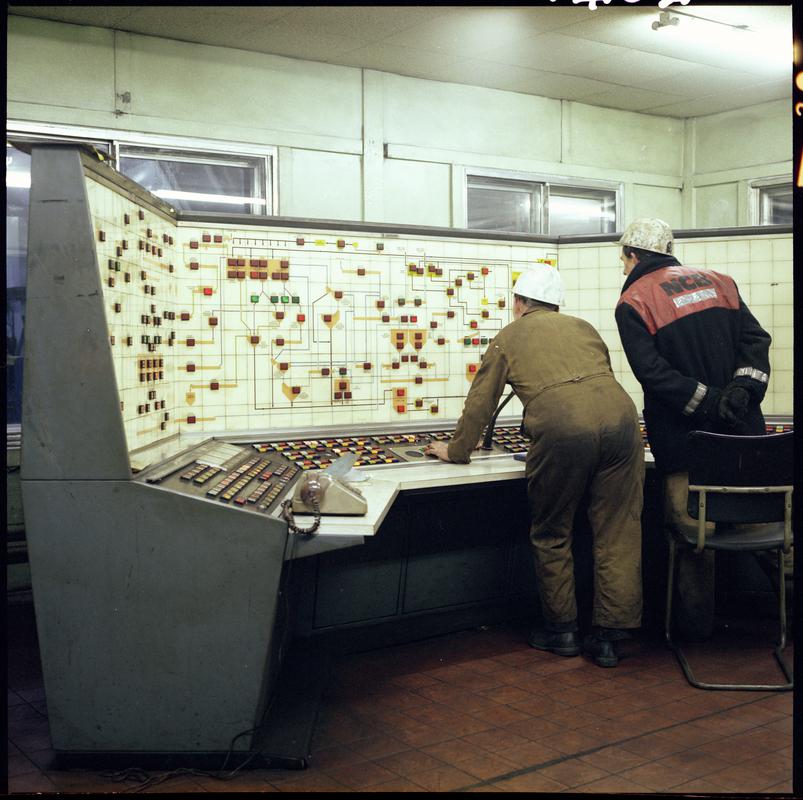 Colour film negative showing two men at the control room at Taff Merthyr Colliery.