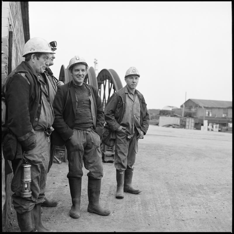 Black and white film negative showing four miners on the surface, Tower Colliery.  &#039;Tower&#039; is transcribed from original negative bag.
