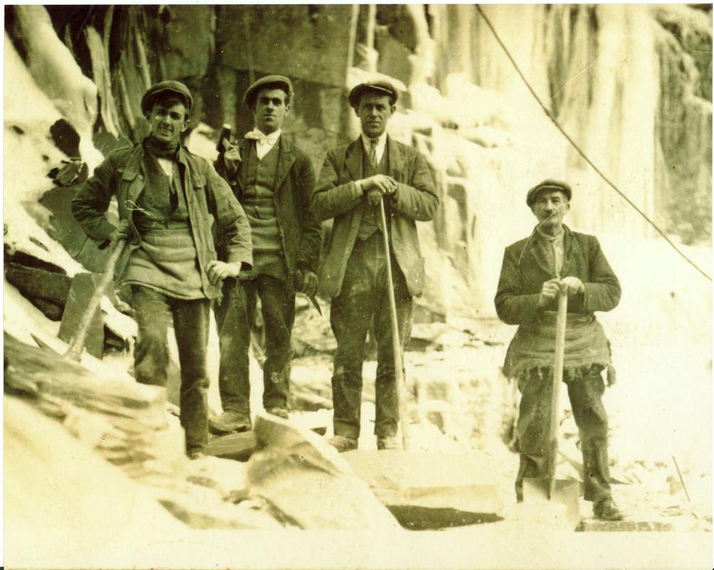 Dick Cae Glas (second from left) and his fellow quarrymen standing in front of a sheet of ice, Dinorwig Quarry