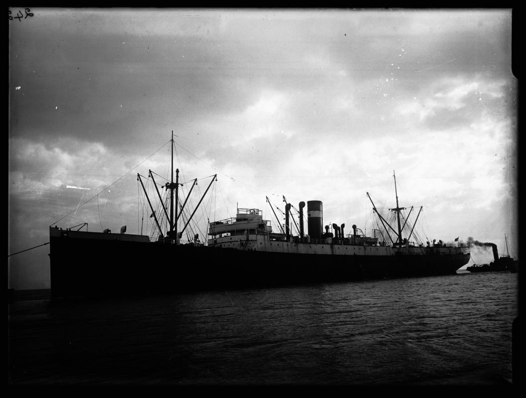 Port broadside view of S.S. DAKOTIAN and tug, c.1936.