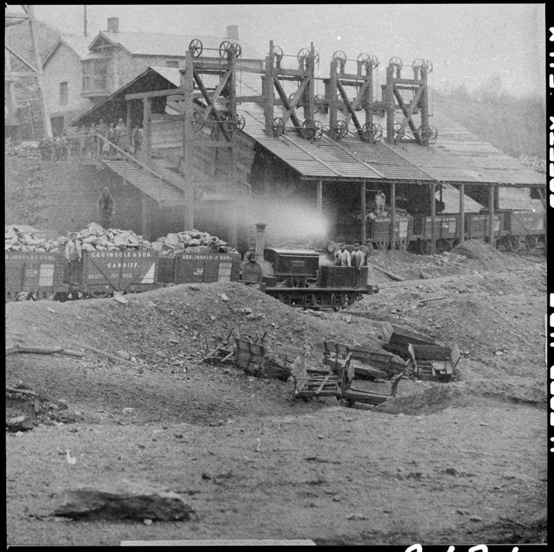 Film negative of a photograph showing a Manning Wardle Locomotive working alongside the screens  at Cymmer Colliery in the 1880s.  In the foreground are the remains of old mine tram waggers.  &#039;Cymmer&#039; is transcribed from original negative bag.