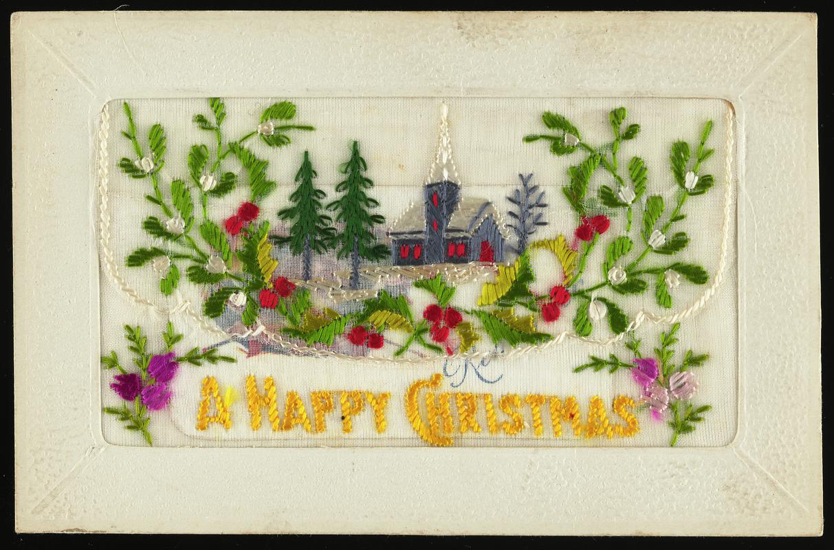 Embroidered silk postcard inscribed A Happy Christmas. Sent from France by Gordon Hobbs to his mother (Mrs Annie Hobbs of 19 Eleanor Street, Cardiff Docks) during First World War. Dated December 21st, probably sent in 1916. Embroidered with mistletoe and holly and church. Flap opening contains a small forget-me-not card. Message on back.