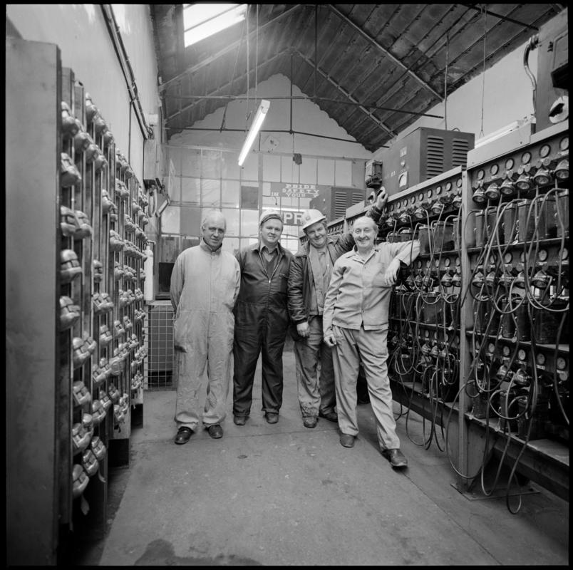 Black and white film negative showing four men in the lamproom, Coegnant Colliery, 25 November 1981.  &#039;25 Nov 1981&#039; is transcribed from original negative bag.