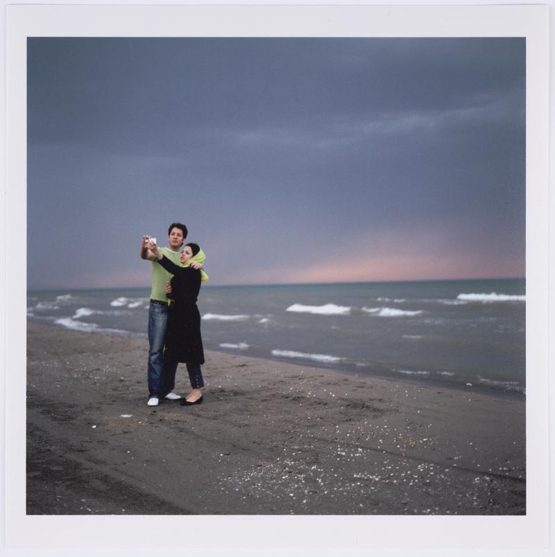 A couple photograph themselves on their mobile phone in front of the Caspian Sea, Ramsar, Iran