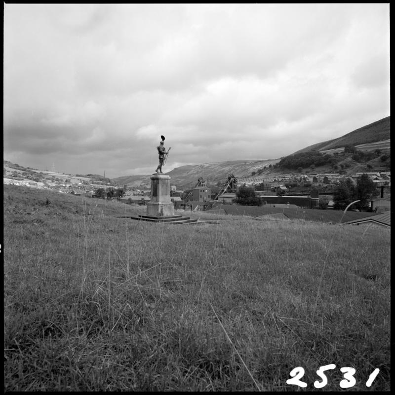 Black and white film negative showing a memorial statue with Merthyr Vale Colliery in the background, 21 September 1981.  &#039;Merthyr Vale 21 Sep 1981&#039; is transcribed from original negative bag.