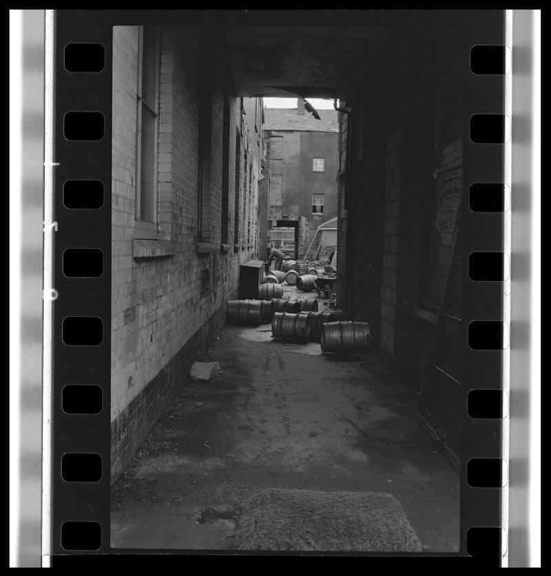 Alleyway alongside Dowlais, with beer barrels on floor.