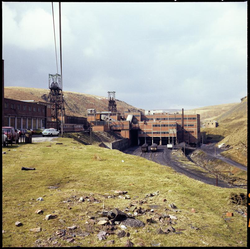 Colour film negative showing a general surface view of Maerdy Colliery.  The brick structure over the railway sidings is the washery.