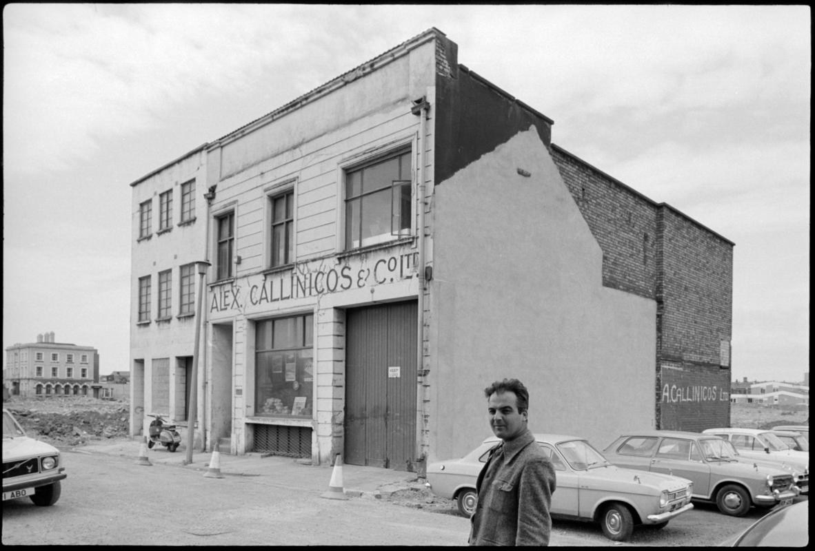 Exterior view of Alex Callincos &amp; Co. Ltd., 45-47 George Street, Butetown. A partner in the Greek owned ship store, Mr V. Antippas is seen standing outside.