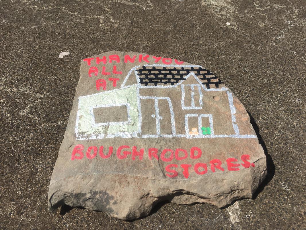 A pebble depicting a painting of Boughrood Stores reading &#039;Thank you all at Boughrood Stores&#039; on Boughrood Bridge, over the River Wye, Boughrood, Powys.