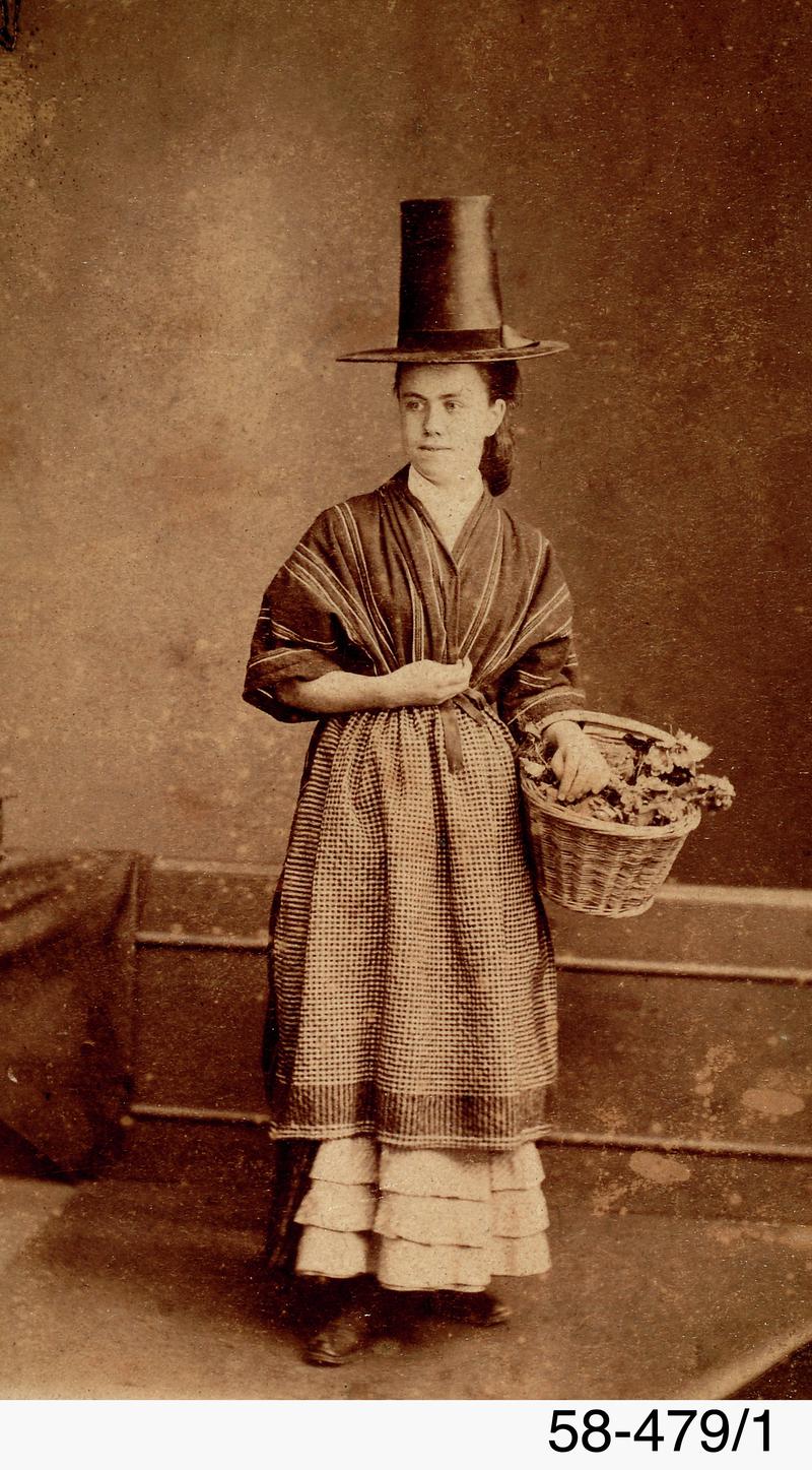 Studio photograph of a woman in Welsh costume holding basket