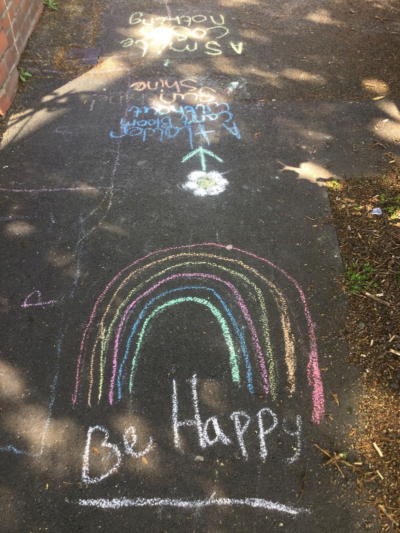 Rainbow and words &#039;Be Happy&#039; chalked on the pavement of a street in Roath, Cardiff.