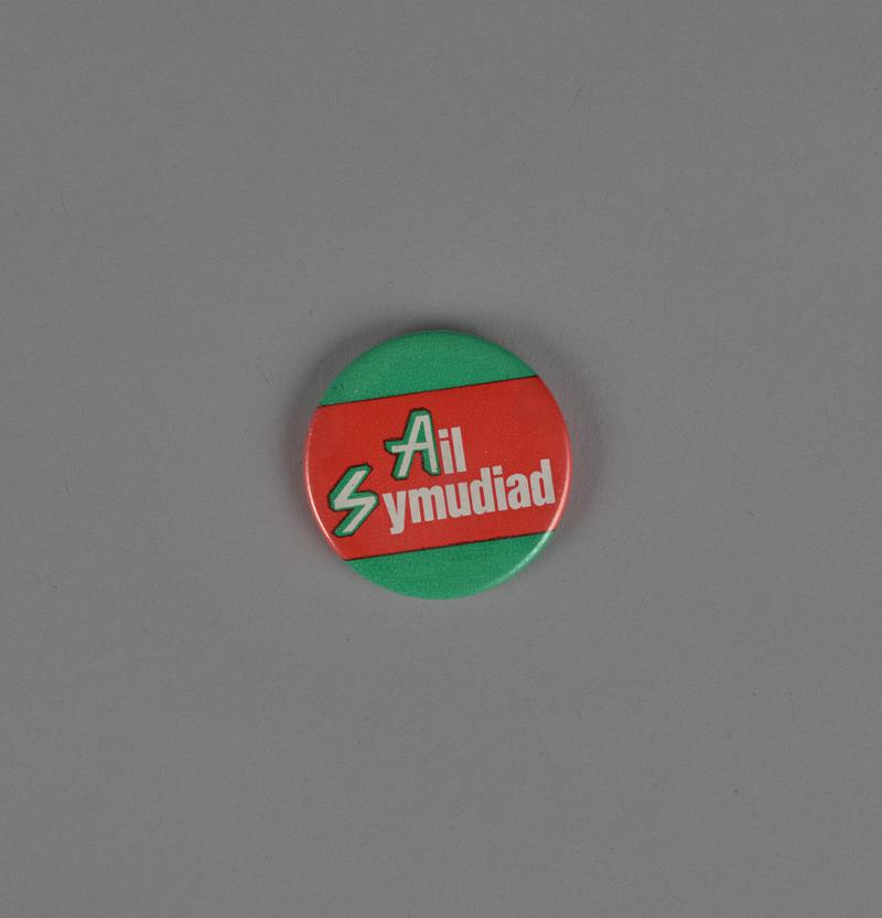 Badge &#039;Ail Symudiad&#039; on green and red background for BBC children&#039;s programme