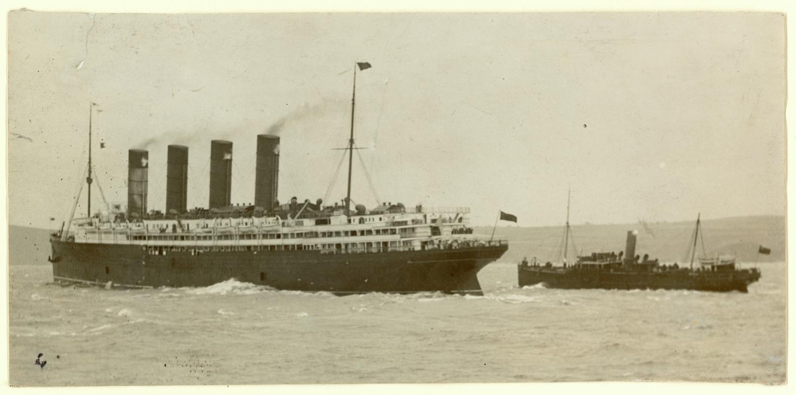 Mail tender S.S. PEMBROKE taking the post on the starboard side of the R.M.S. LUSITANIA at Fishguard.