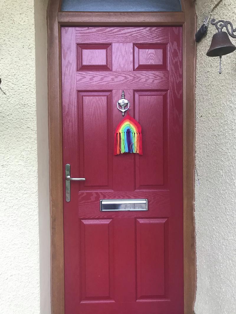 Crocheted rainbow on door in Glanaman.