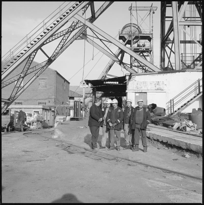 Black and white film negative showing a group of miners and both headframes, Western Colliery . &#039;Western&#039; is transcribed from original negative bag.