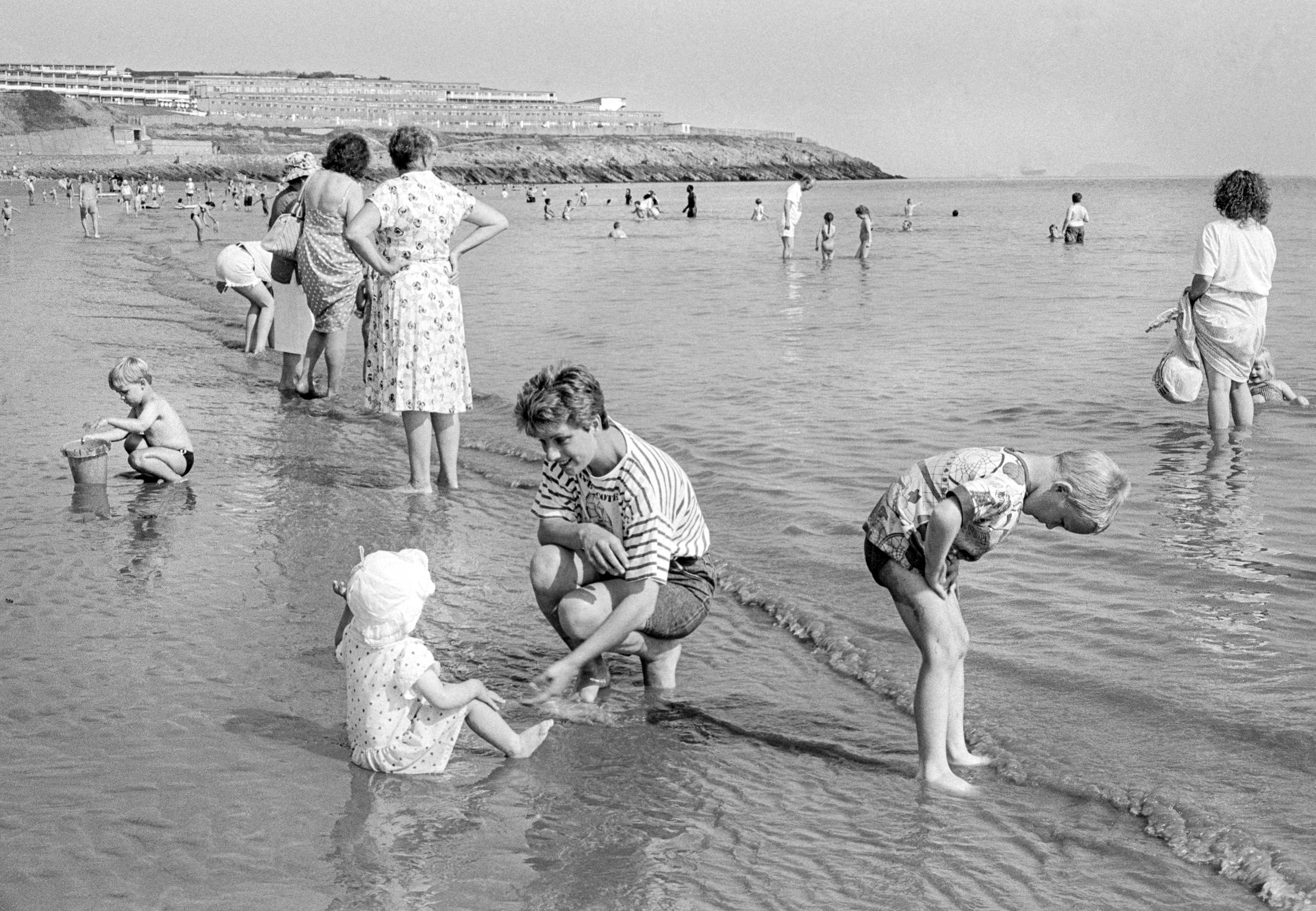 Families and children having normal fun at the edge of the sea in Barry Island, Wales