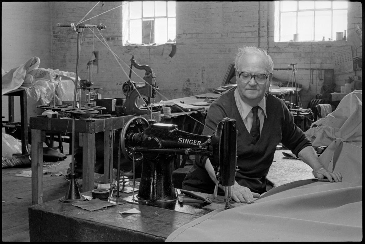 Mr Wheeler using a Singer sewing machine at Jenkin Jones and Son sailmakers, 12 Hurman Street, Cardiff Docks.