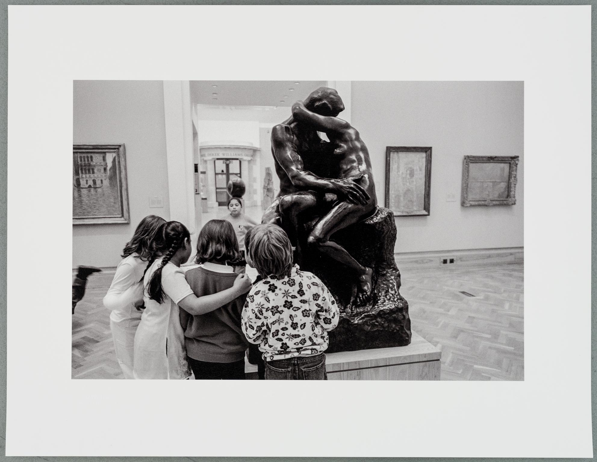 In the National Museum some students from a school party find interest in Rodin's sculpture 'The Kiss'. Cardiff, Wales