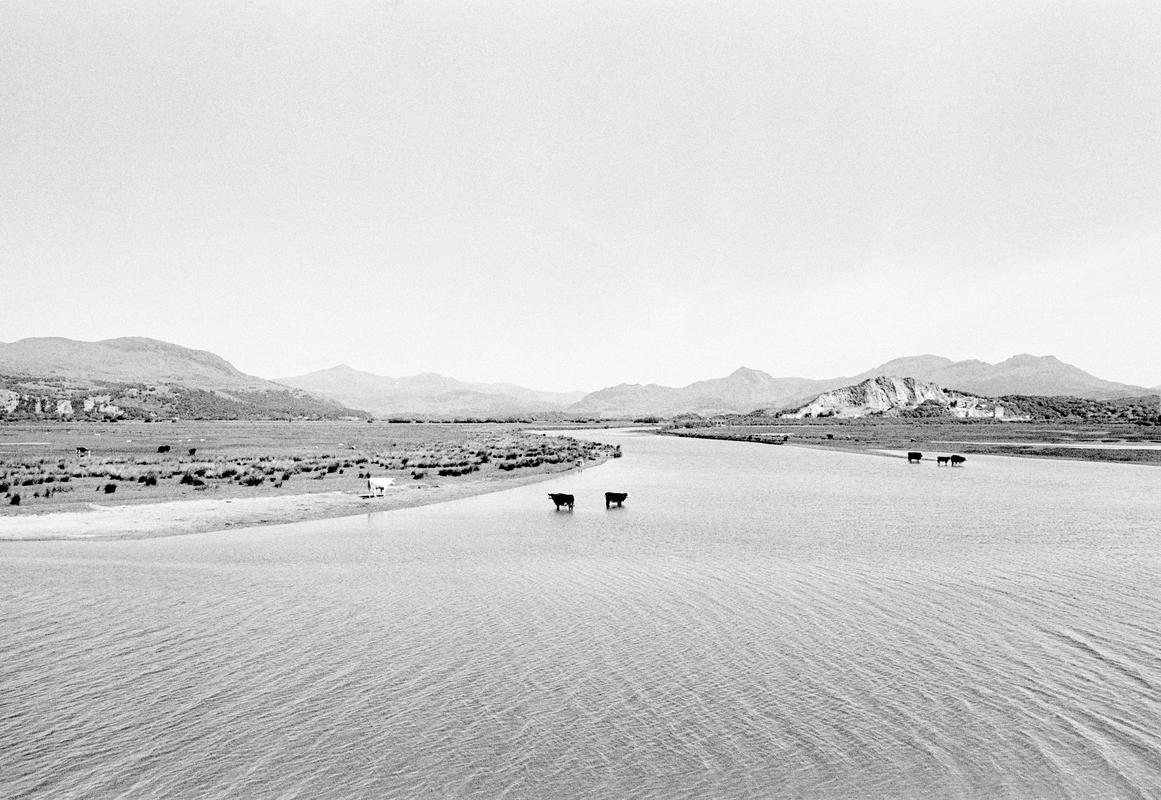 GB. WALES. Looking North West from Portmadoc Bay towards Yr Wyddfa, Mnt Snowdon, the highest mountain in Wales, in the background (photographed from the bank). 1984.