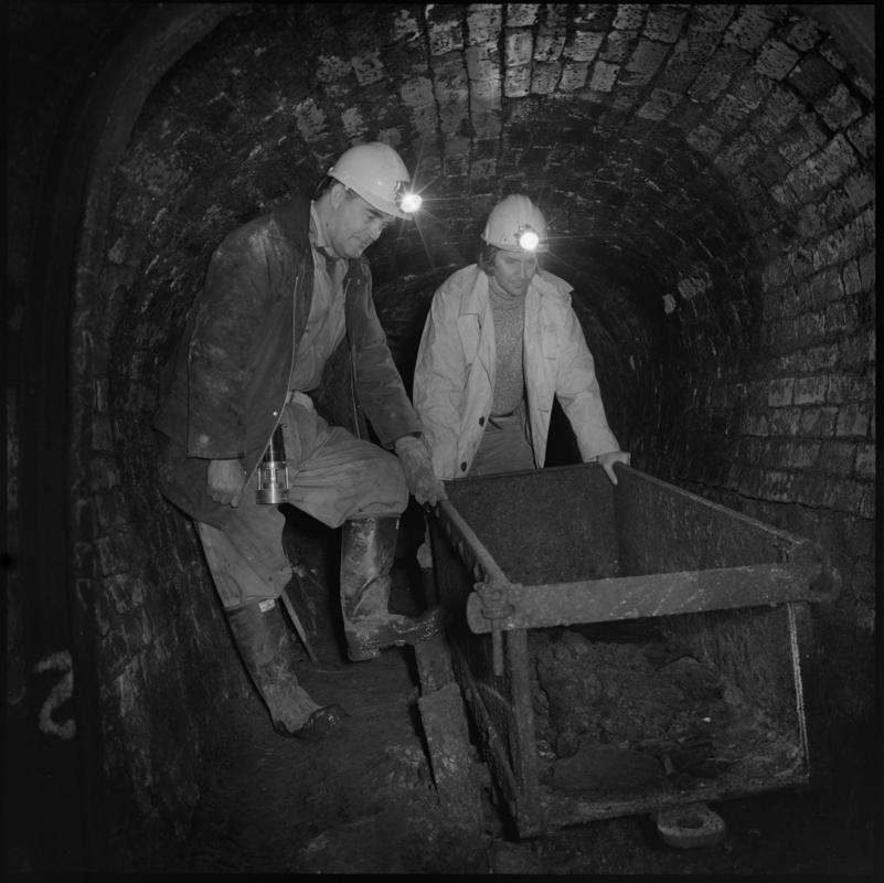 Black and white film negative showing two men pushing a dram, Big Pit Colliery.  &#039;Big Pit Blaenavon&#039; is transcribed from original negative bag.  Appears to be identical to 2009.3/2999.