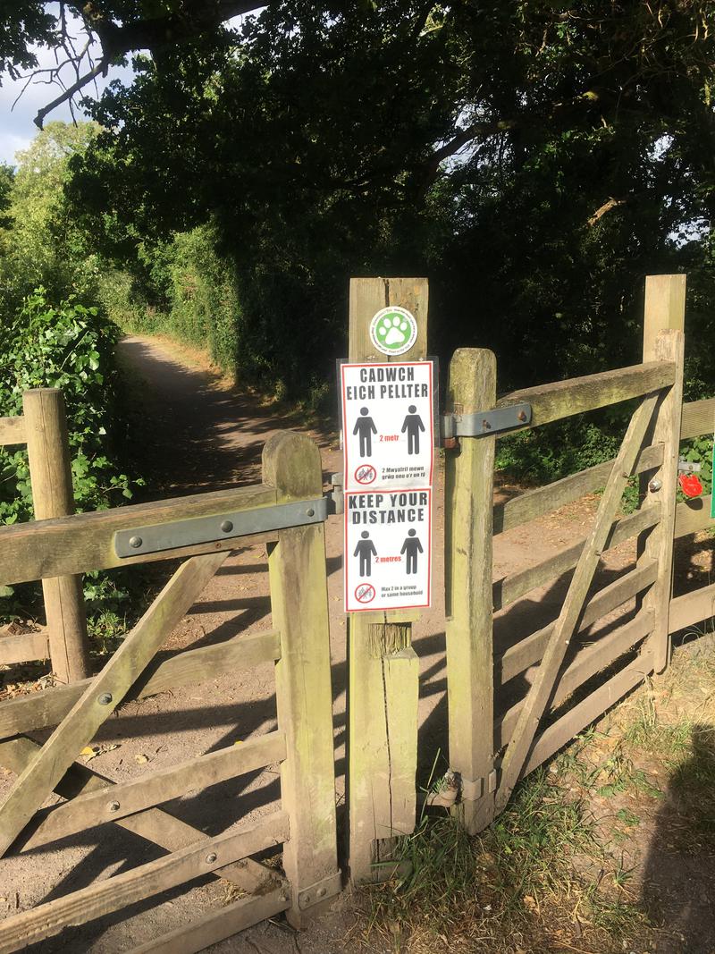 2m social distancing signage attached to a gate in Cosmeston Lakes Country Park, Vale of Glamorgan.