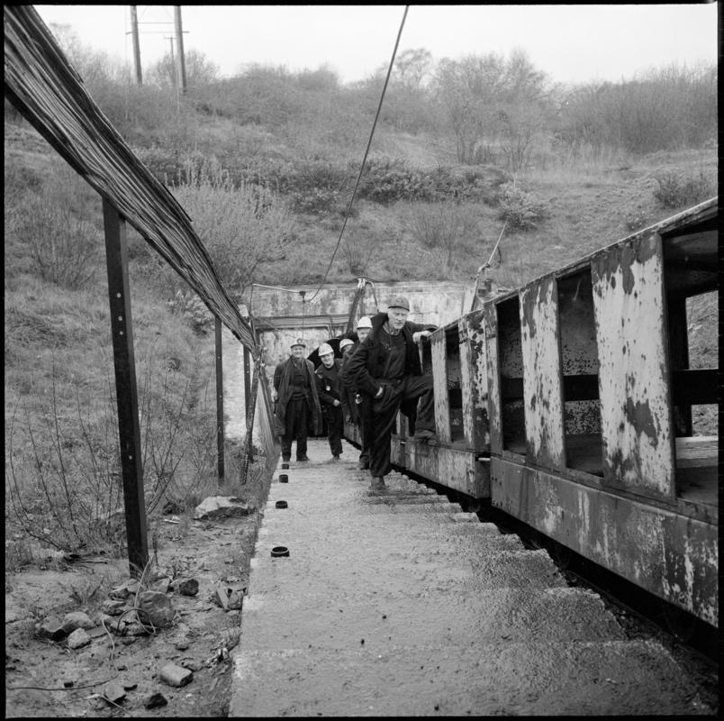 Black and white film negative showing men beside the manriding train at the entrance of the mine, Cwmgwili Colliery.  &#039;Cwmgwili&#039; is transcribed from original negative bag.
