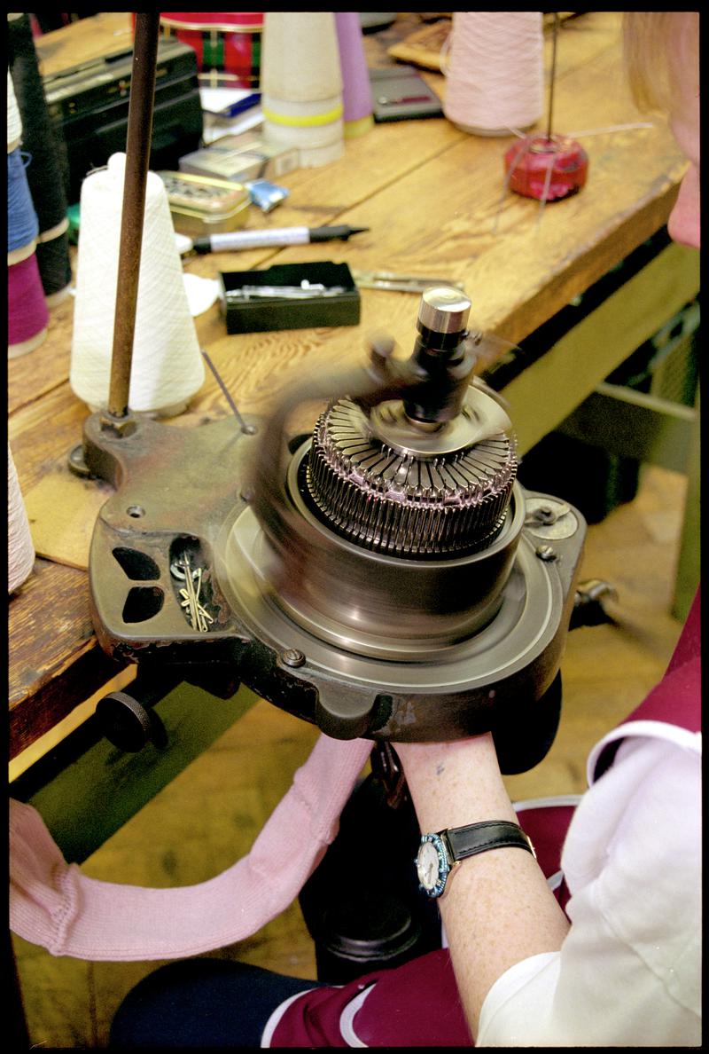 Andrea Rockman setting needles on a sock knitting machine. Corgi Hosiery Ltd factory, Ammanford, 1 July 2002.