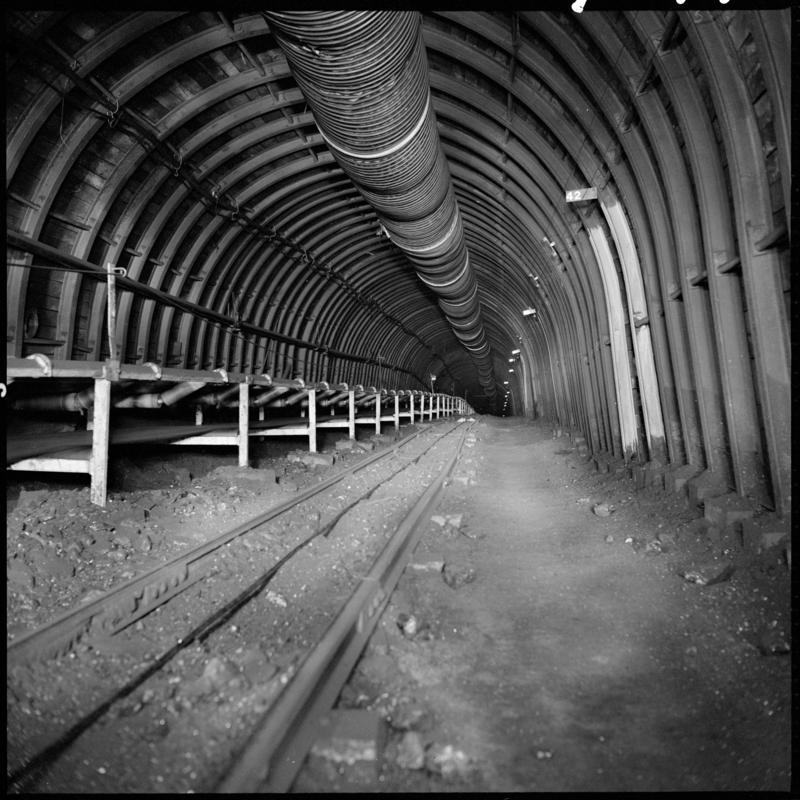 Black and white film negative showing a roadway with high speed conveyor, Blaengwrach Mine, 1 November 1979.  &#039;Blaengwrach 1 Nov 1979&#039; is transcribed from original negative bag.