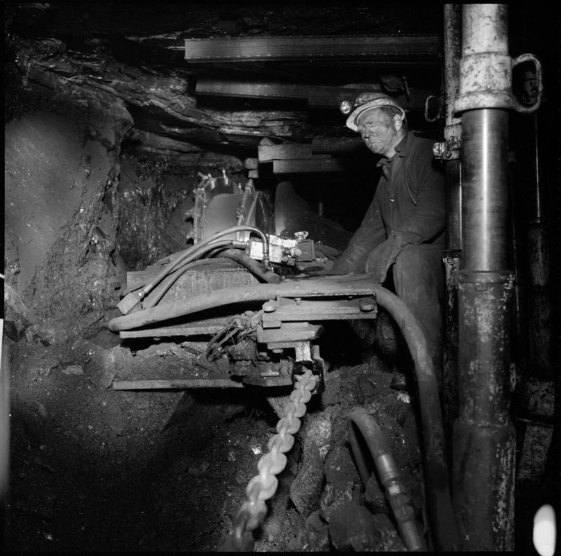 Black and white film negative showing an overman inspecting a shearer, Coegnant Colliery 1978-1979.  &#039;Coegnant 1978-9&#039; is transcribed from original negative bag.