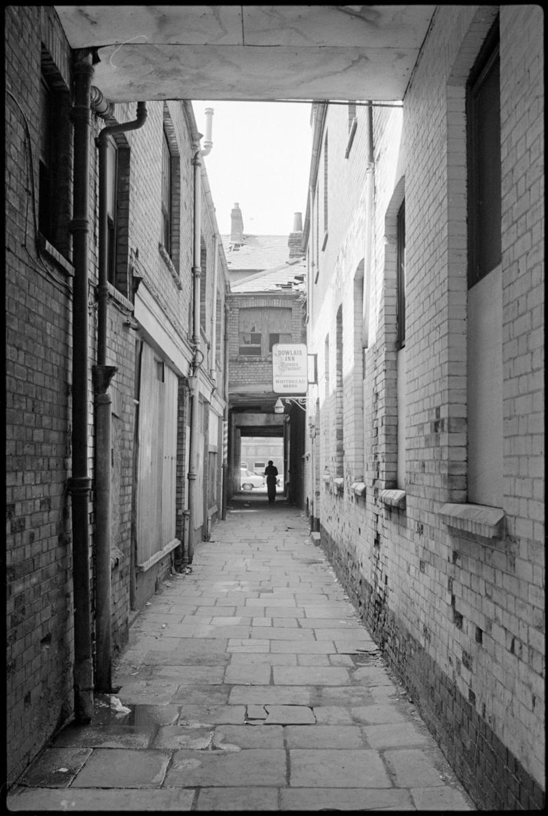 Alleyway from West Bute Street to Mount Stuart Square, Butetown, with broken &#039;Dowlais Inn&#039; sign.