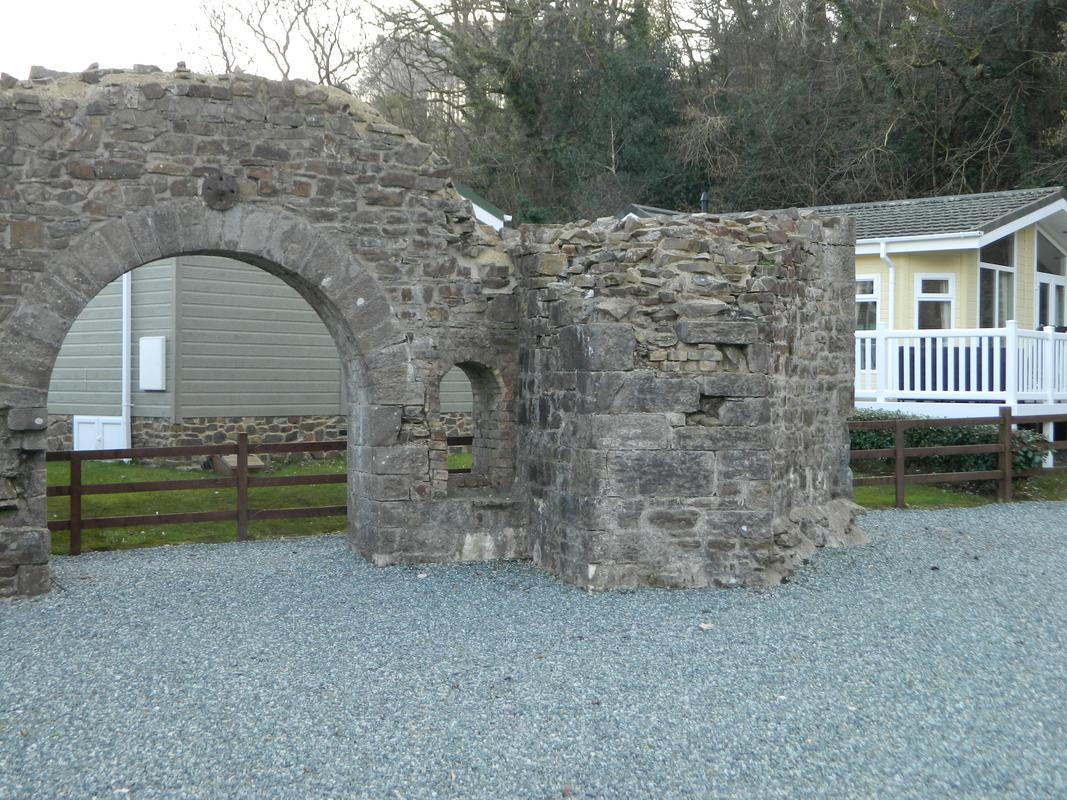 Kilgetty Ironworks, Stepaside: surviving fragment of no.2 blast furnace viewed from north east; the curved surface to the right formed part of the annular blast passage; the arch to the left is the west extremity of the south wall of the cast house.