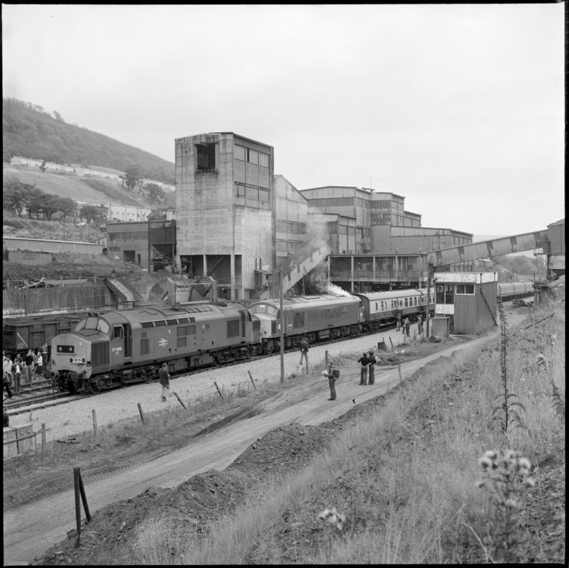 Black and white film negative showing a locomotive passing through Abertillery New Mine, 1977. &#039;1977&#039; is transcribed from original negative bag.