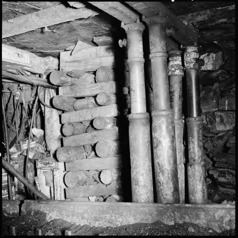 Black and white film negative showing steel props and stacked timber,  underground at Merthyr Vale Colliery.