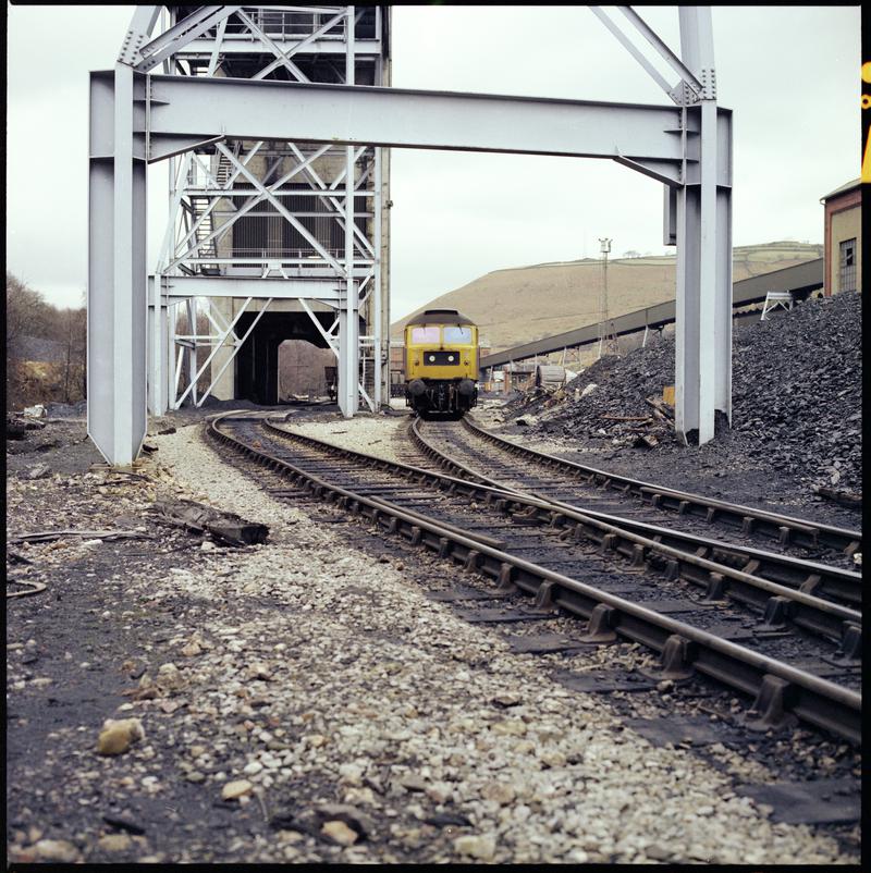 Colour film negative showing a locomotive passing through Taff Merthyr Colliery.