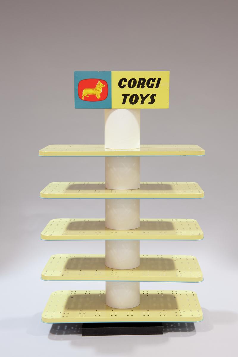Corgi Toys shop display stand. Central revolving pole with five blue and cream tinplate shelves and &#039;Corgi Toys&#039; with dog symbol surrounding the hidden handle.