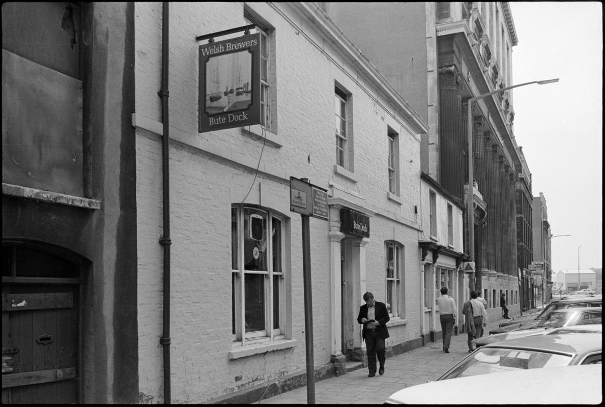 Exterior view of the Bute Dock public house with people walking past, West Bute Street, Butetown.
