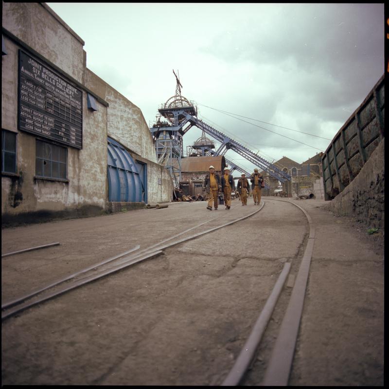 Colour film negative showing miners at the end of their shift walking away from pit top, Six Bells Colliery.  &#039;Six Bells&#039; is transcribed from original negative bag.