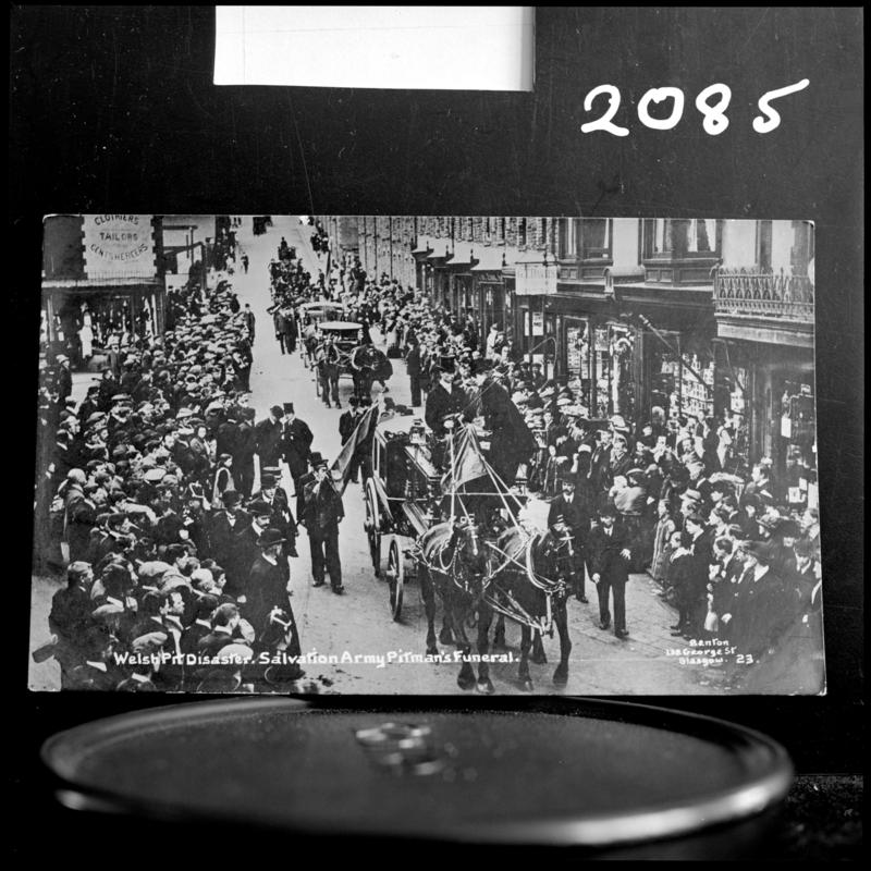 Black and white film negative of a photograph showing a funeral procession passing through Senghenydd.  Caption on photograph reads &#039;Welsh Pit disaster.  Salvation Army Pitman&#039;s funeral&#039;.
