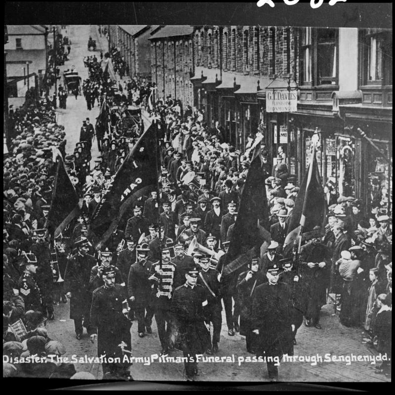 Black and white film negative of a photograph showing a funeral procession passing through Senghenydd.  Caption on photograph reads &#039;The Salvation Army Pitman&#039;s funeral passing through Senghenydd&#039;.